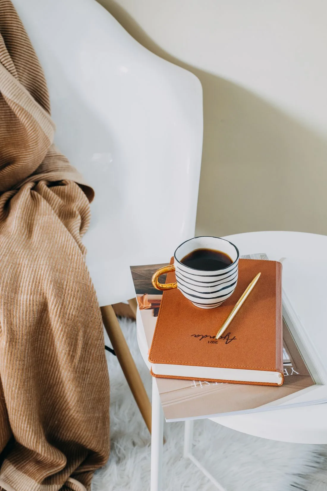 Coffee and a closed notebook on a chair