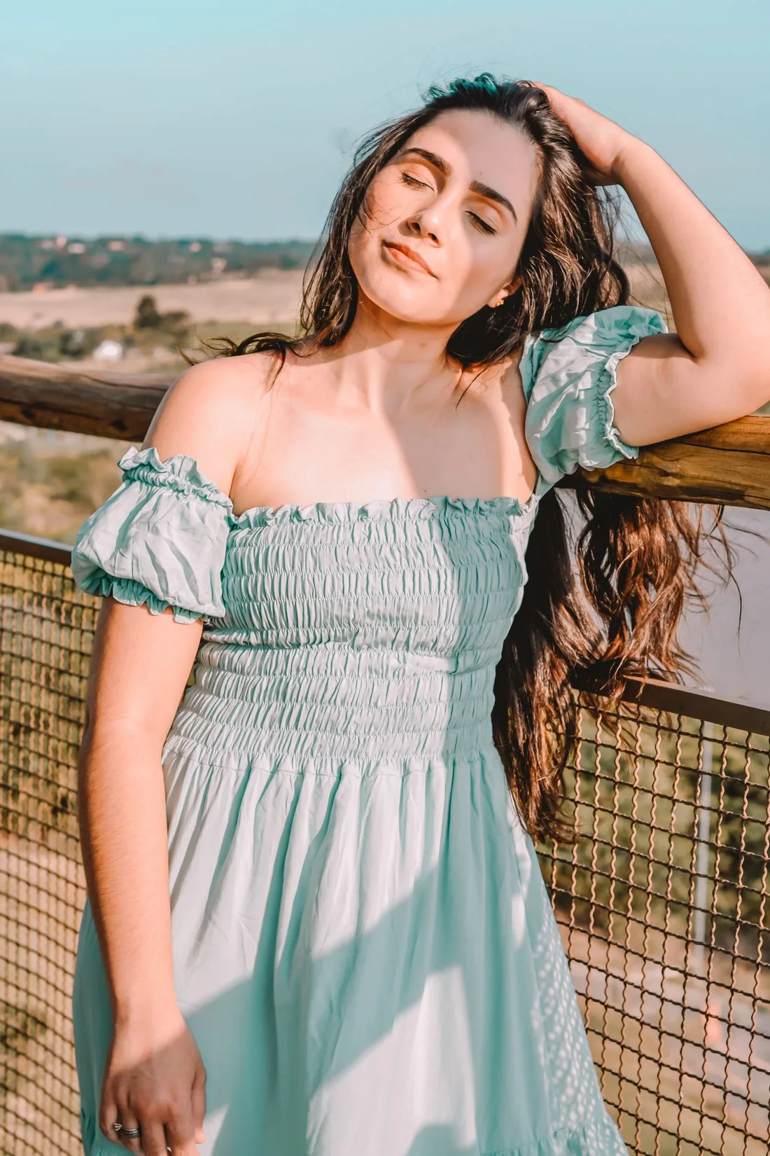 Woman in an off-shoulder green summer dress outdoors