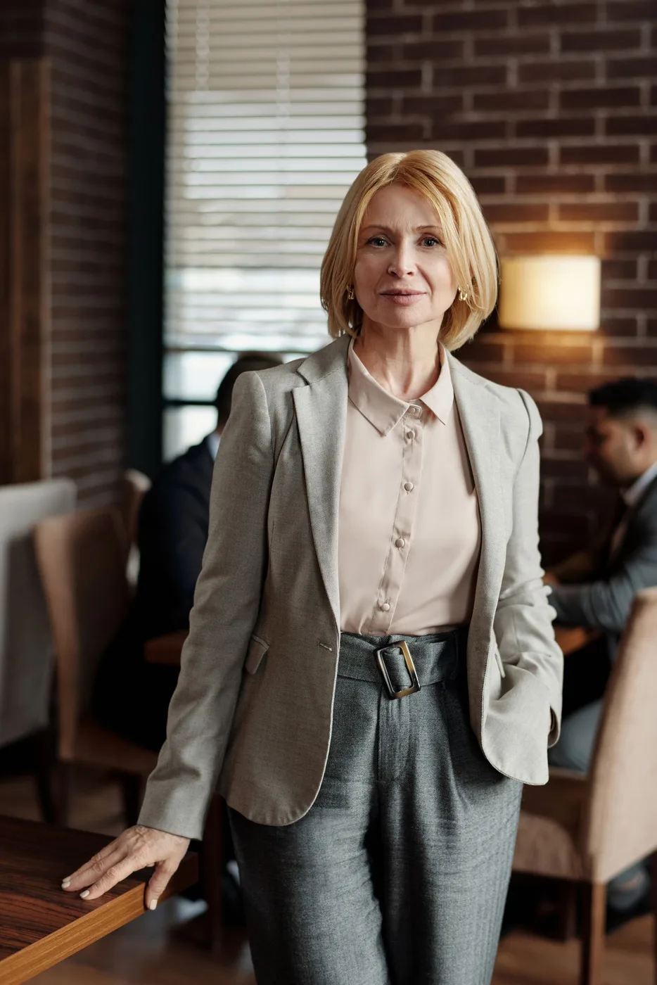 Woman wearing a blazer and tailored trousers indoors