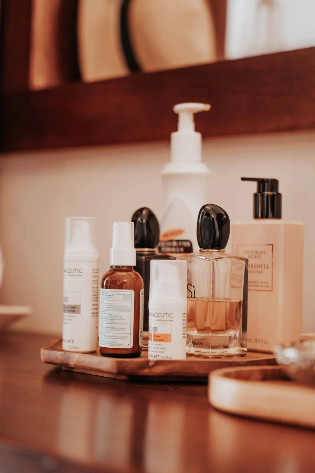 Cosmetic bottles arranged on a wooden bathroom tray