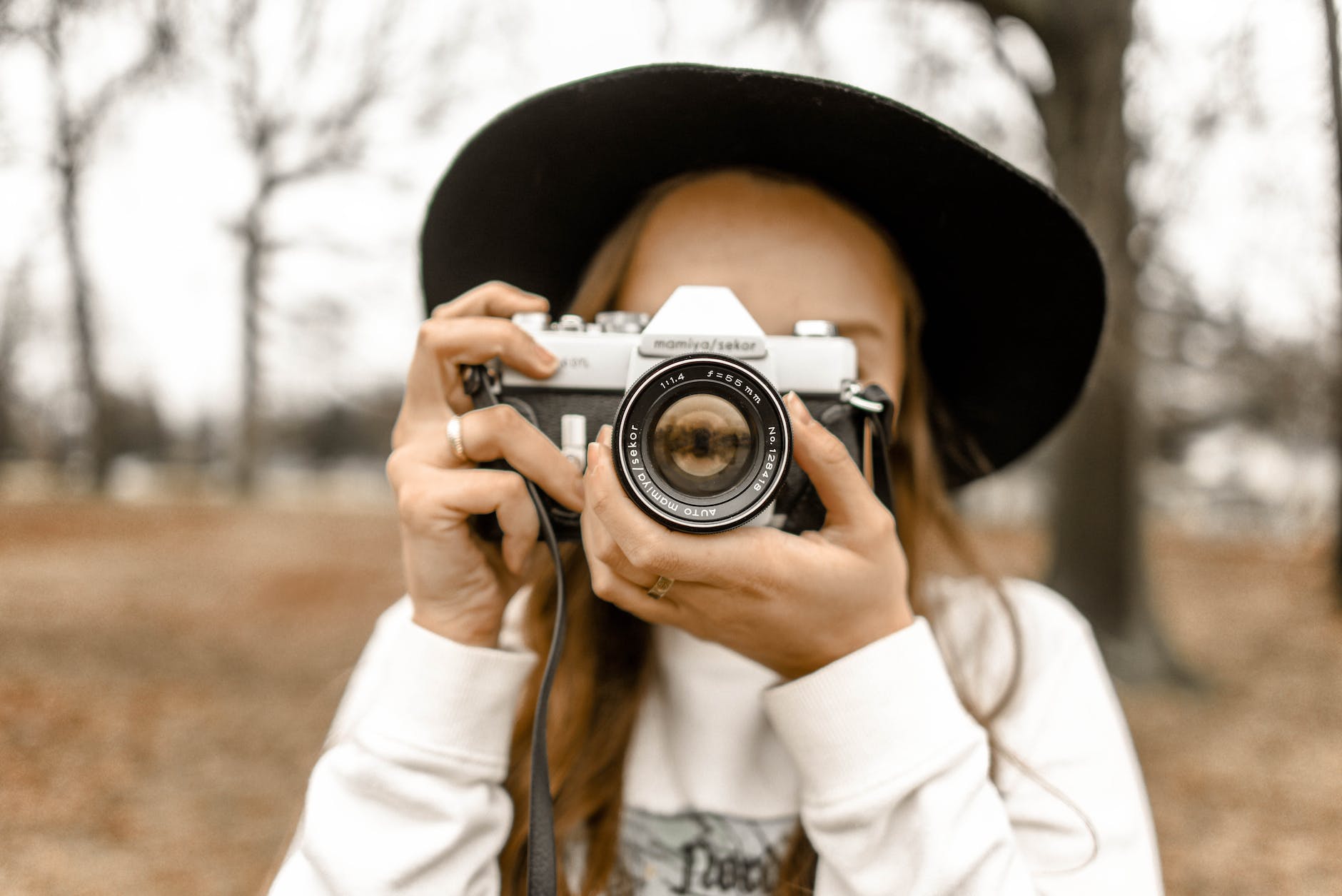 selective focus photography of woman using white and black slr camera