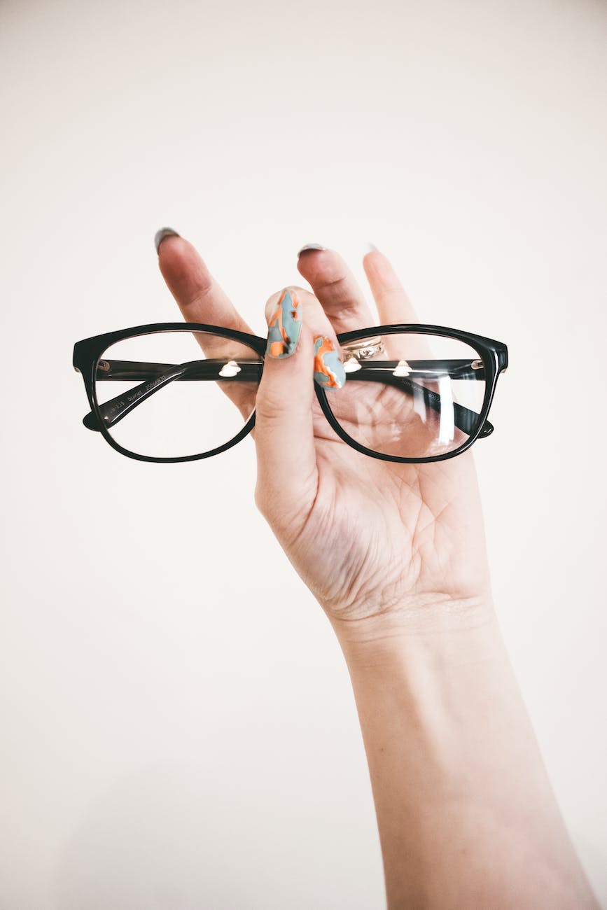 photo of person holding eyeglasses