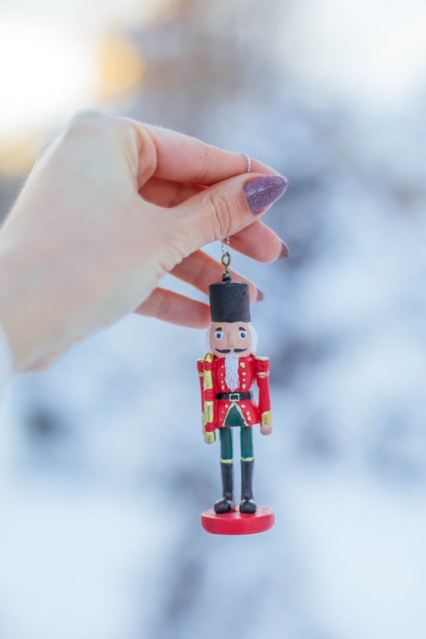 female hand holding nutcracker ornament
