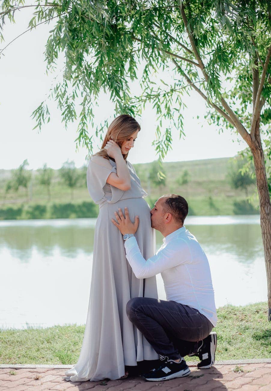 man kissing his partner pregnant belly