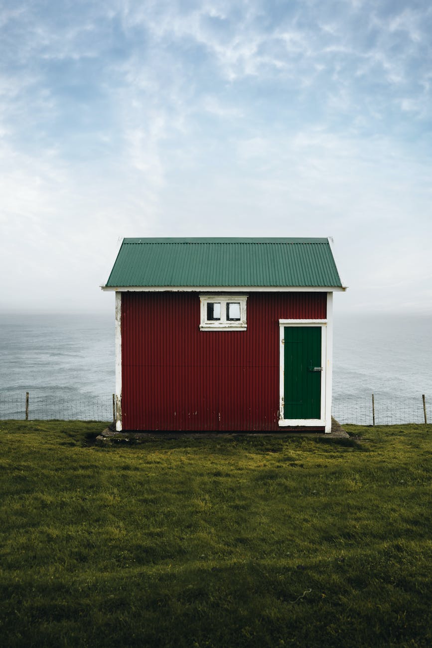 small house standing in meadow by sea