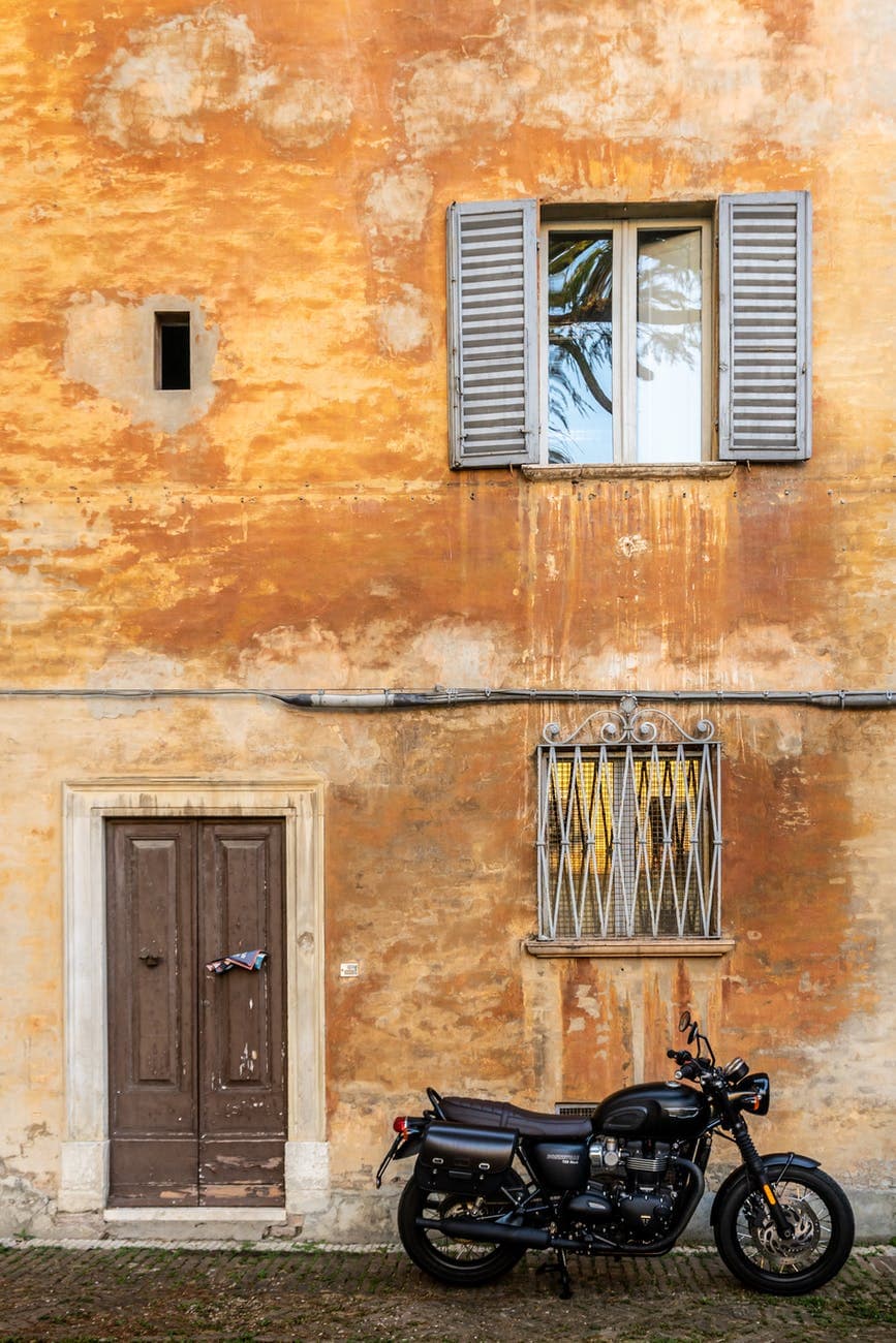photography of motorcycle parked near house
