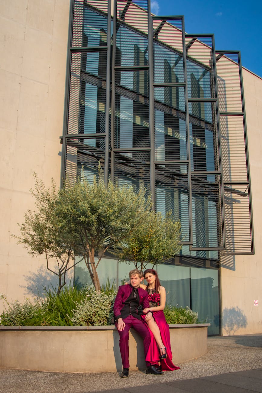 man and woman sitting beside tree