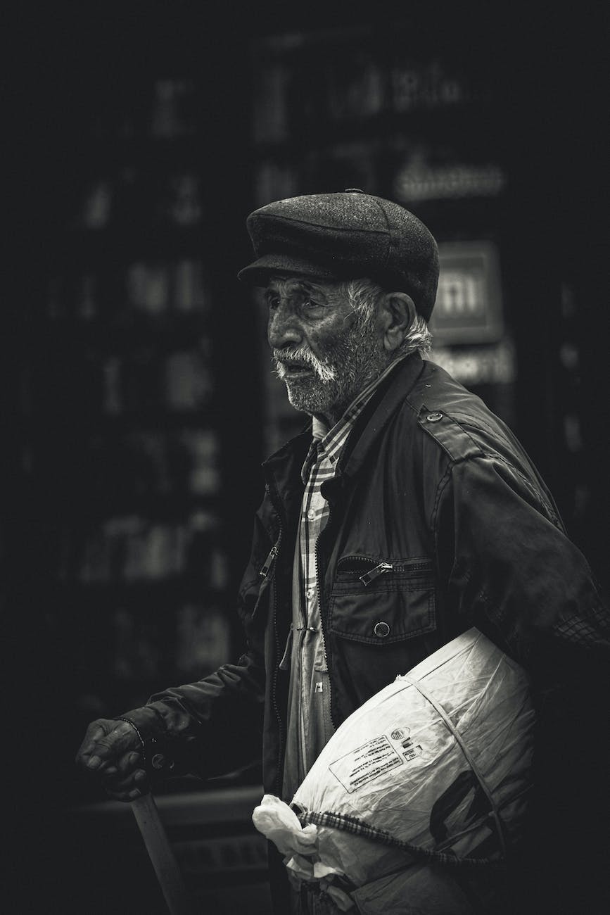 an old man with a bag walks down the street