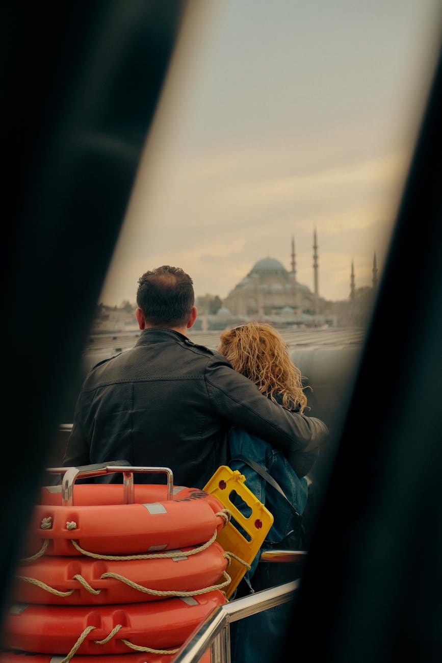 a couple on a cruise in the bosphorus strait looking at the istanbul skyline