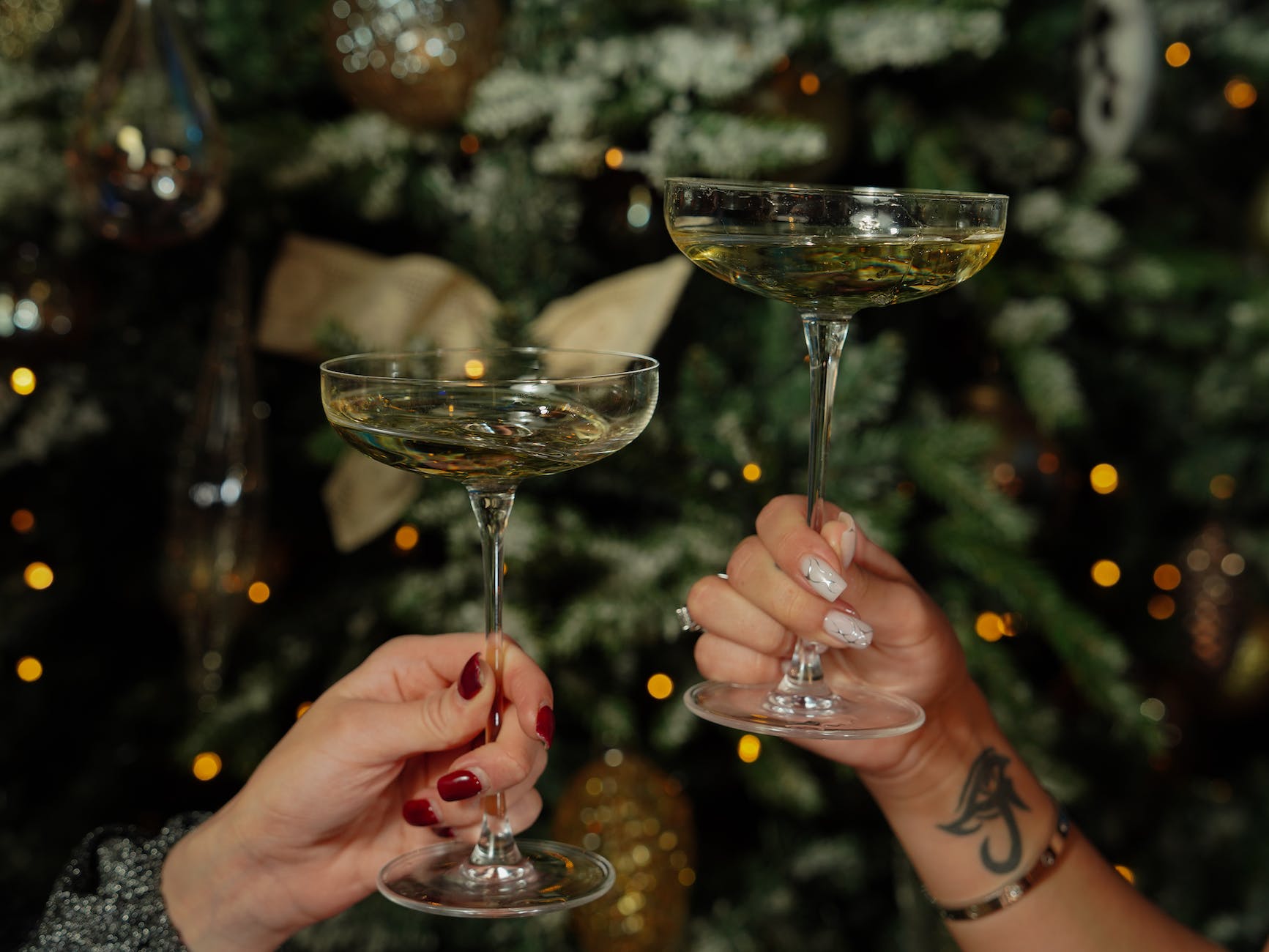 women holding cocktails on the background of a christmas tree