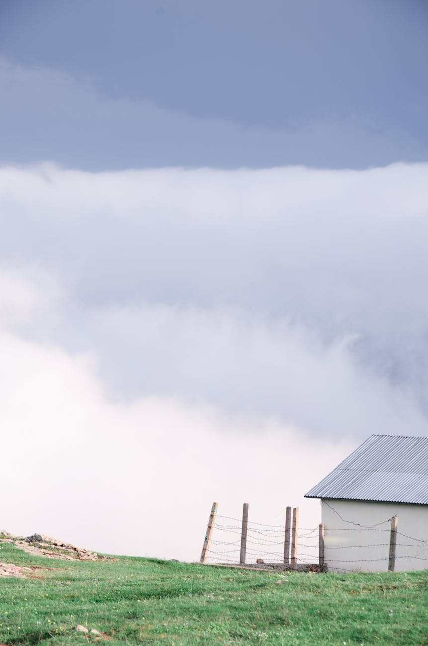 photo of a metal roofed white house on a grassy field