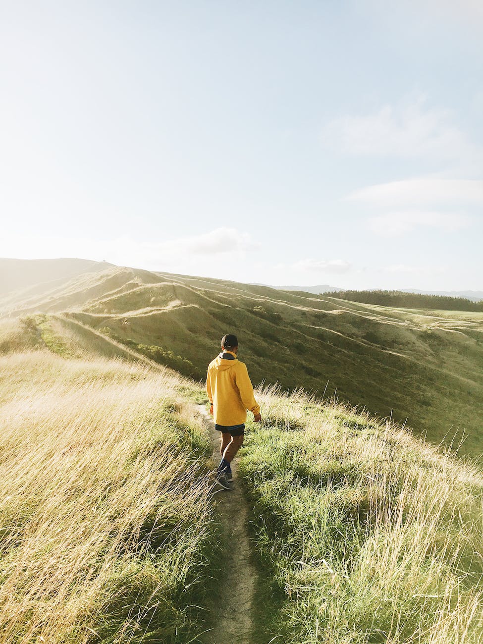 back view of a man standing in a footpath towards the hills