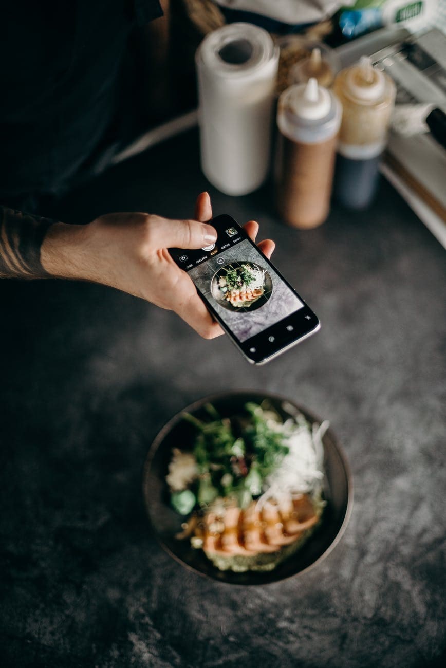 person taking photo of dish in bowl