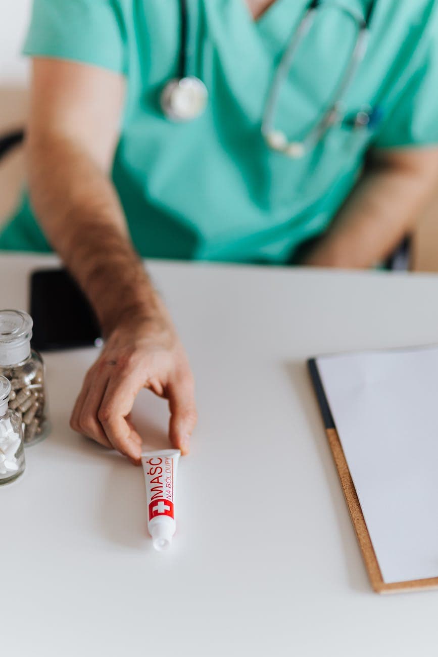 crop male doctor giving ointment tube to patient