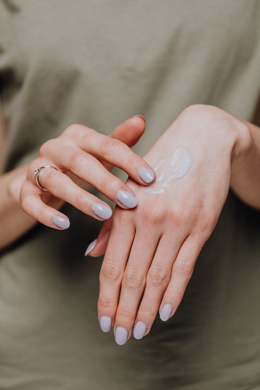 crop woman applying cream on hands