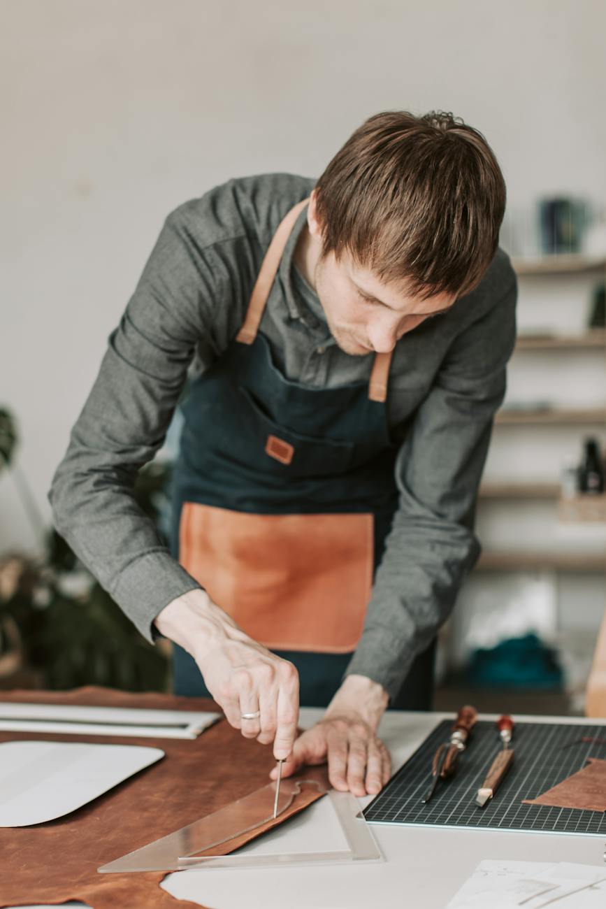 a leathersmith cutting brown leather strap