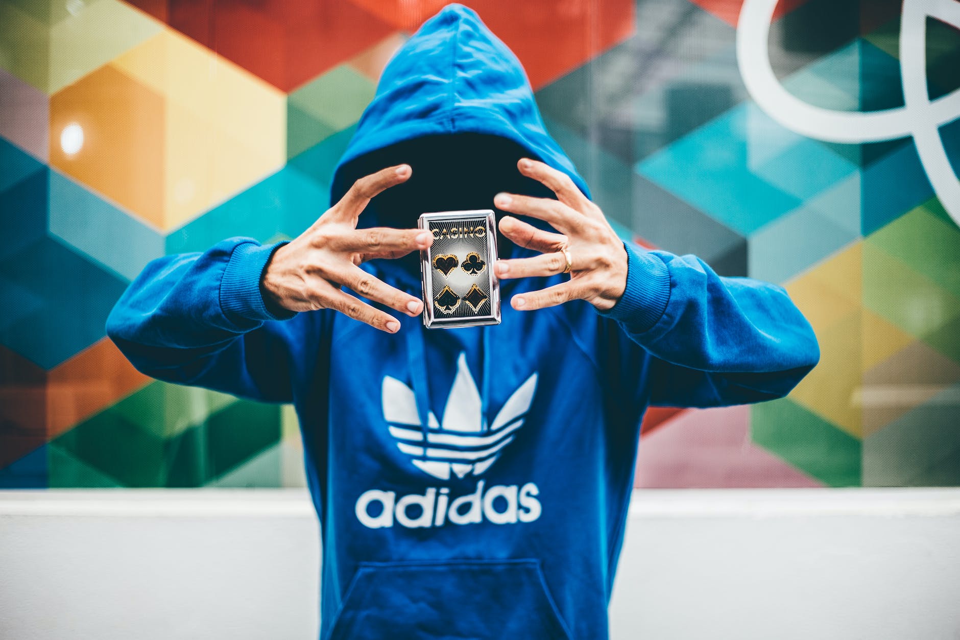 man in blue adidas hoodie doing magic trick