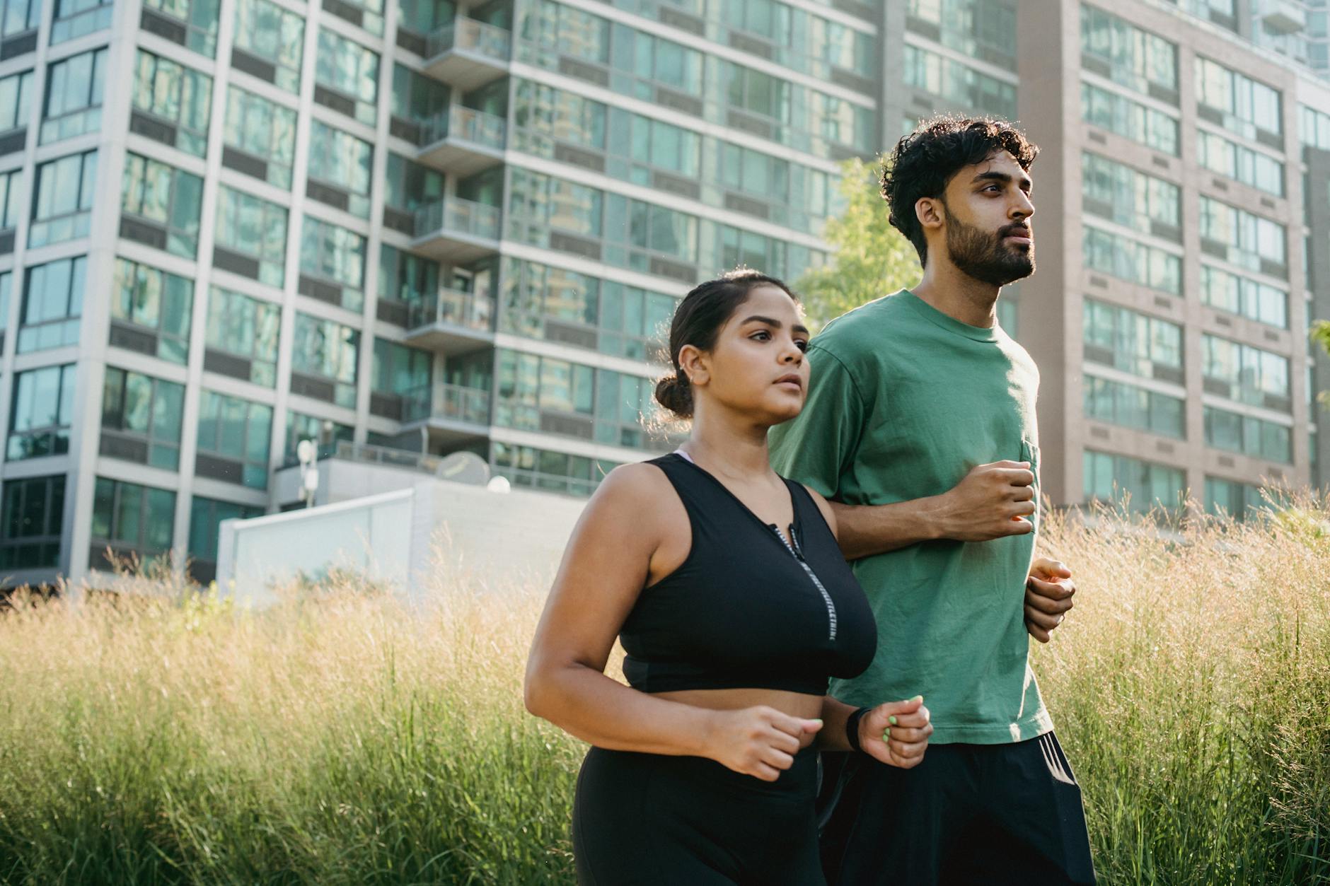 couple jogging through tall glass