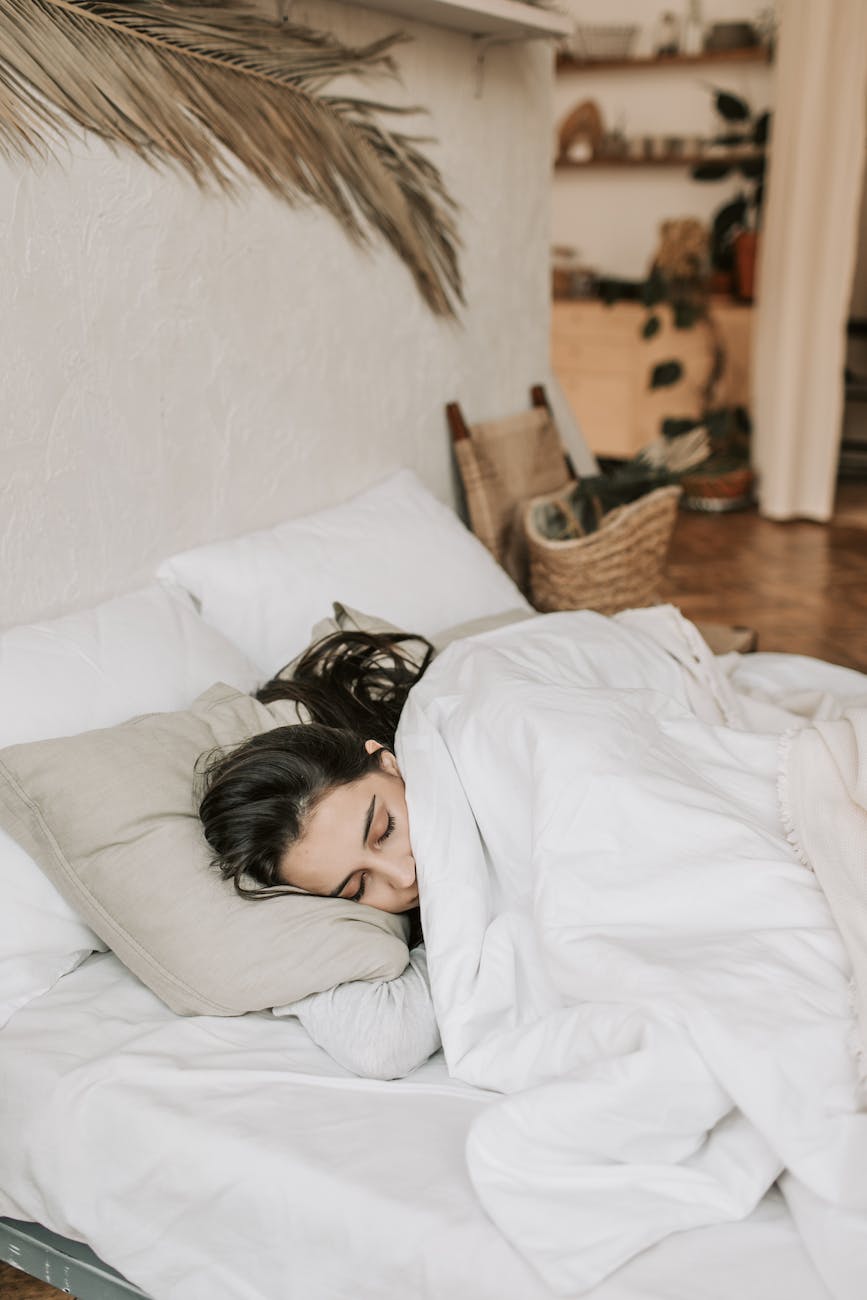 woman sleeping on a bed with white blanket