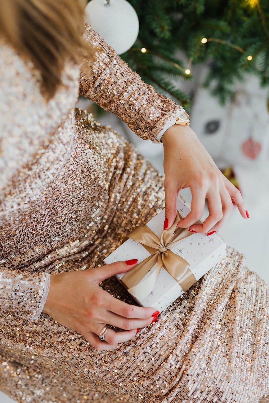 woman in elegant dress opening christmas gift