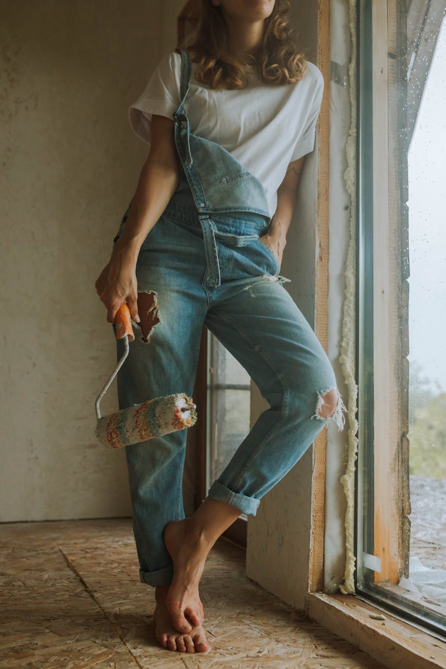 woman in white shirt holding a paint roller