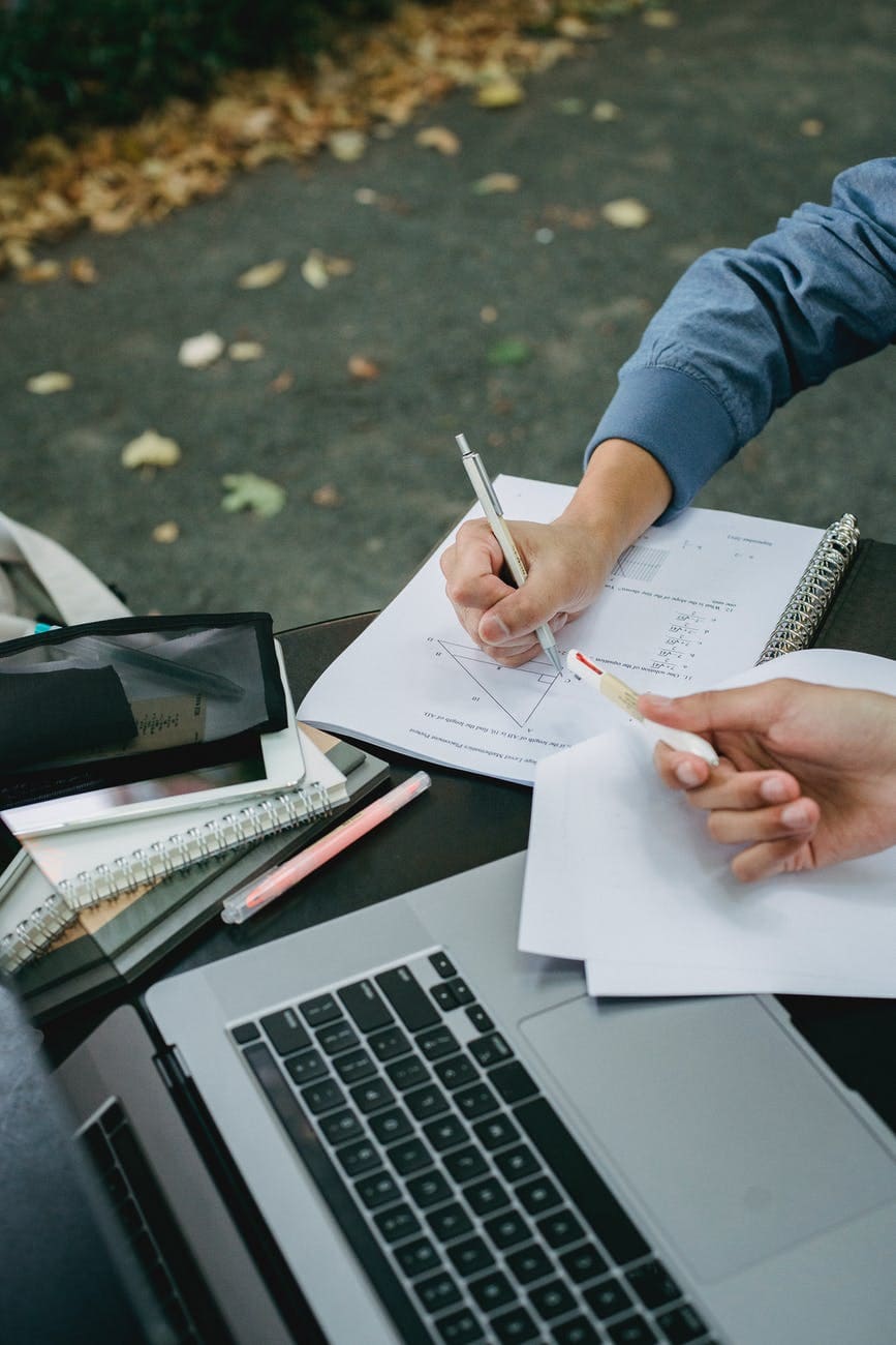 crop unrecognizable male students studying together in park