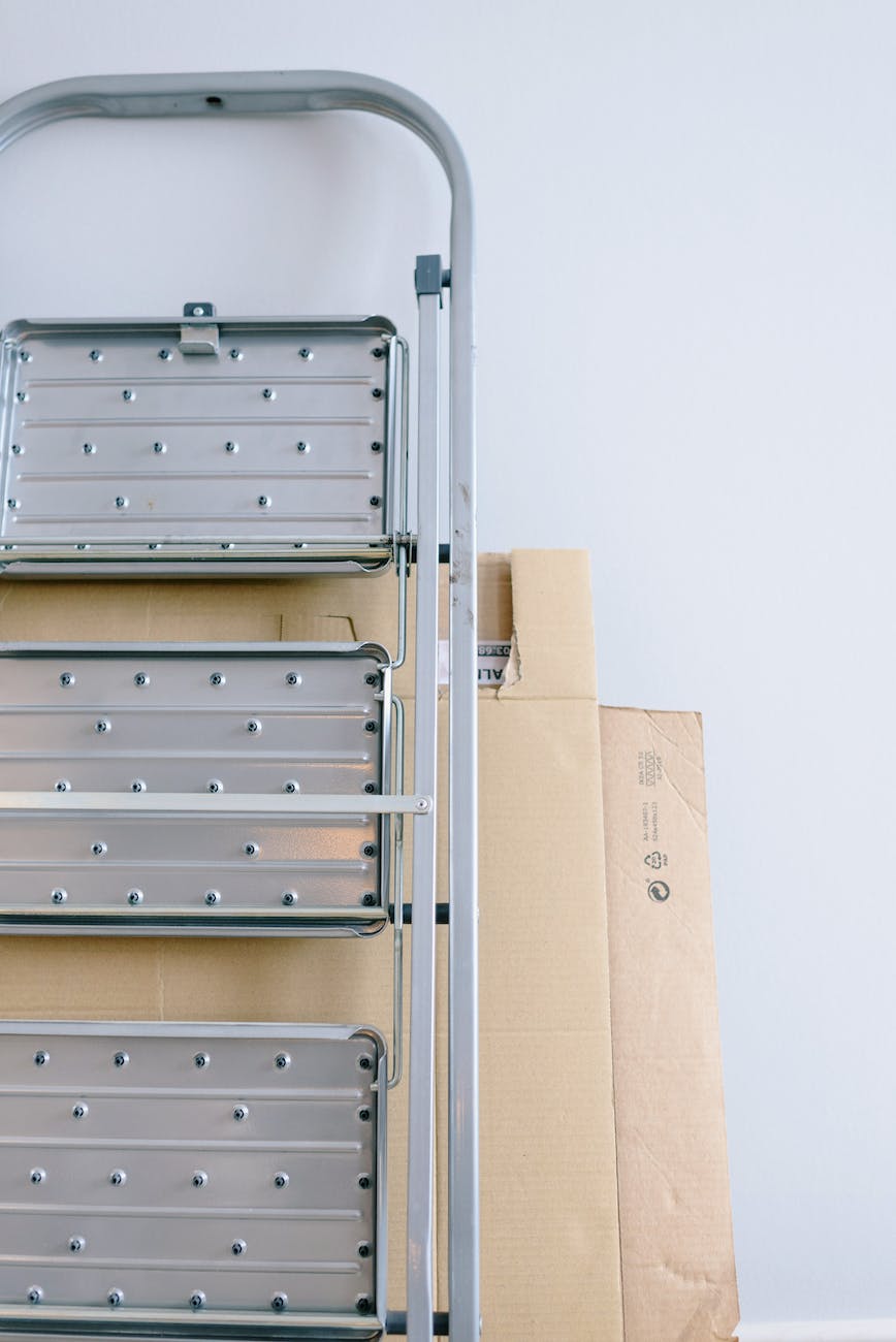 cardboard boxes and metal ladder in room