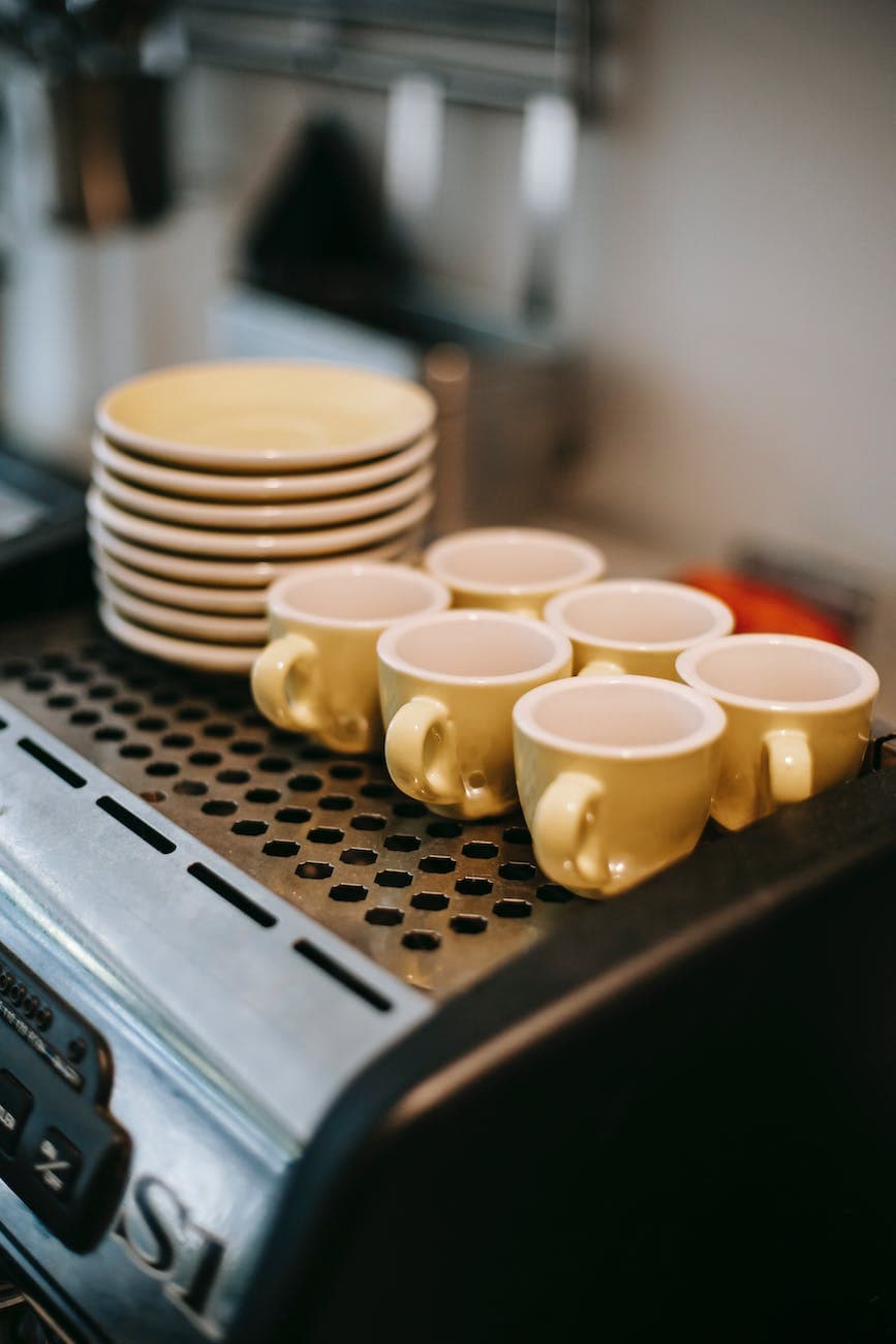 cups and saucers on coffee machine