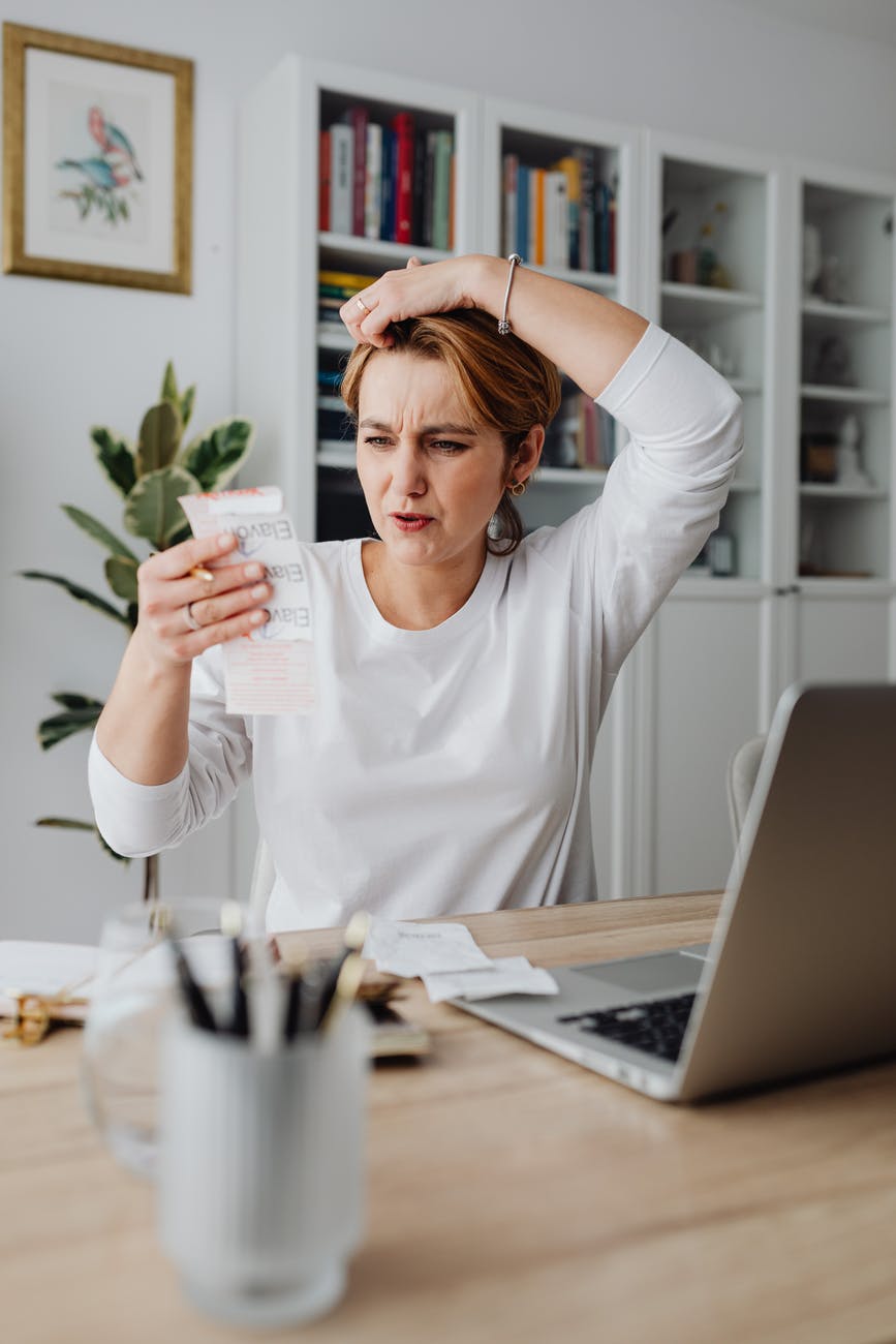 woman looking at a receipt and making a surprised face