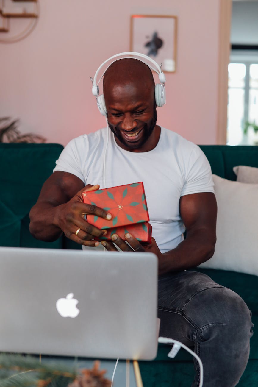 man in white crew neck t shirt opening a gift