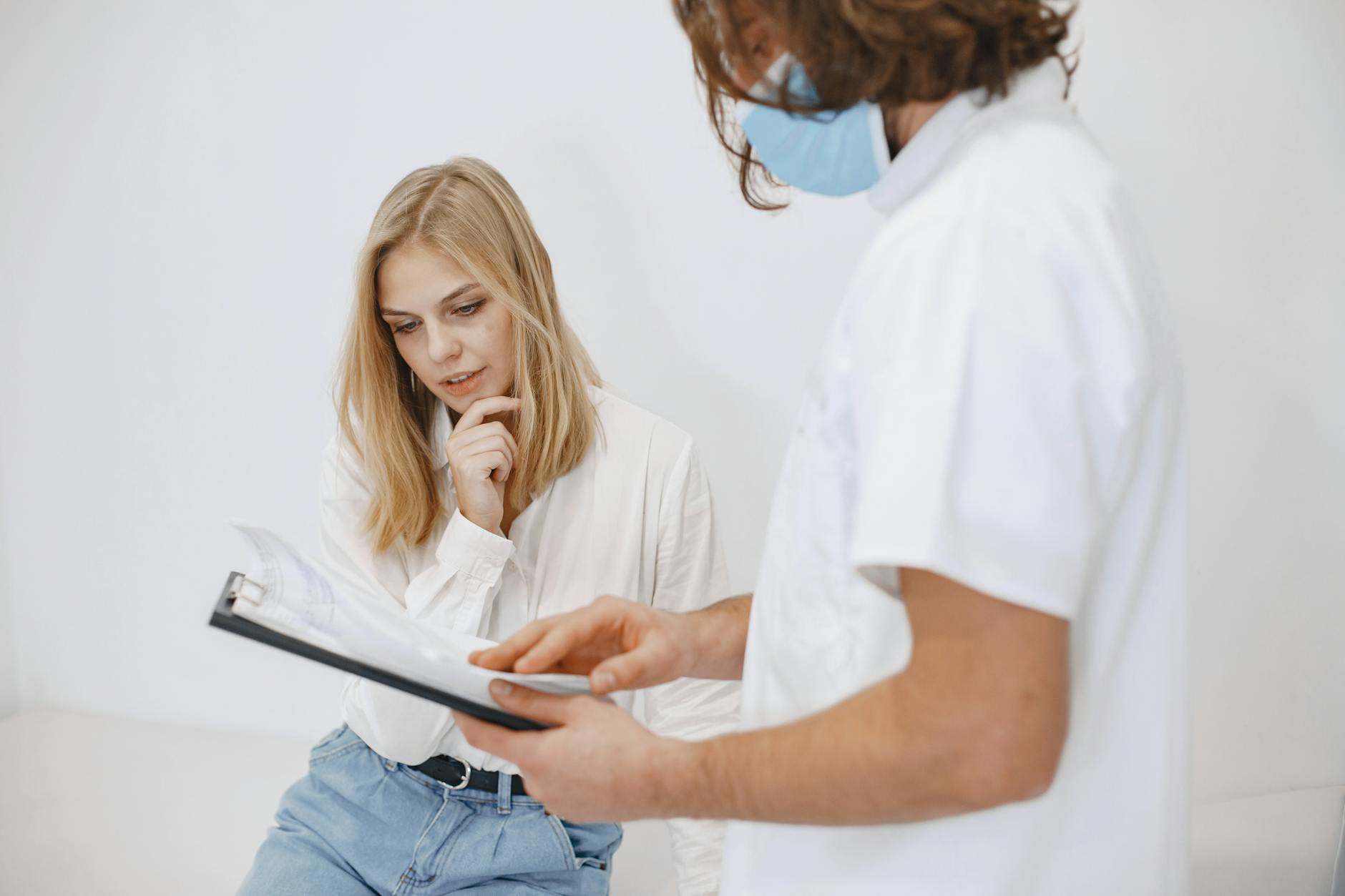 a doctor and patient looking at the diagnosis on a clipboard