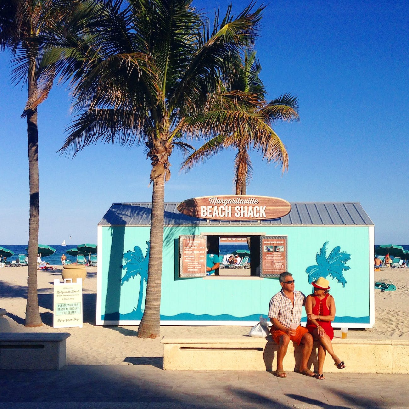 a couple sitting on the bench in the beach