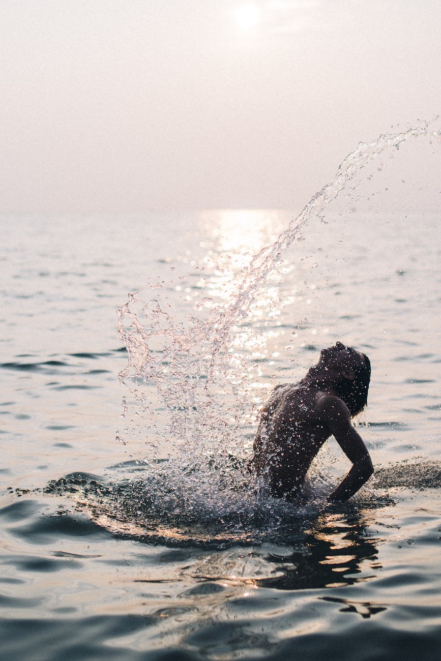 shirtless man on body of water