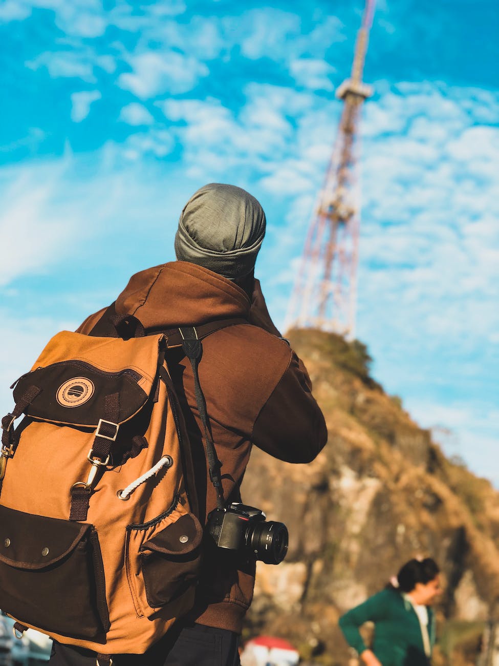 focus photography of person wearing brown and black jacket with brown and black backpack