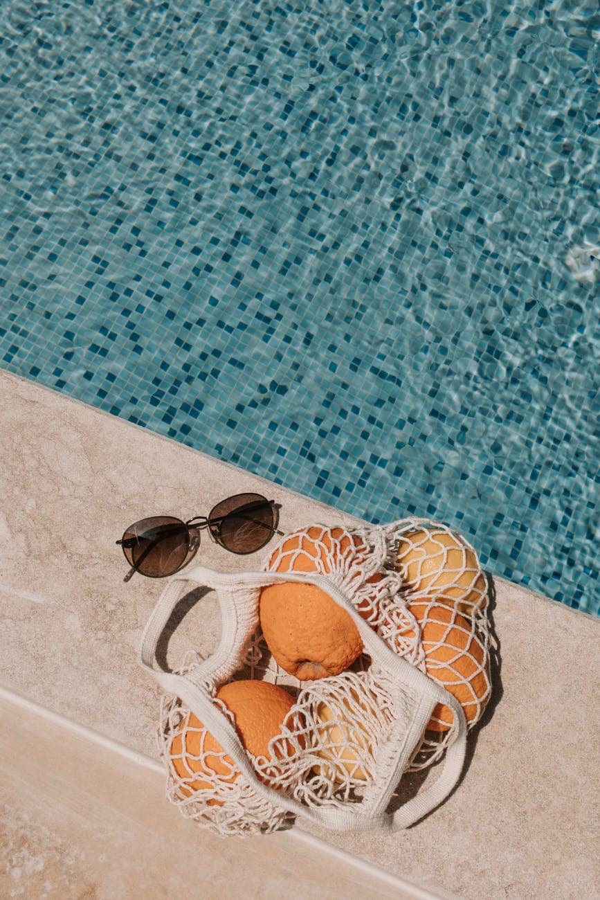basket of orange fruits on poolside