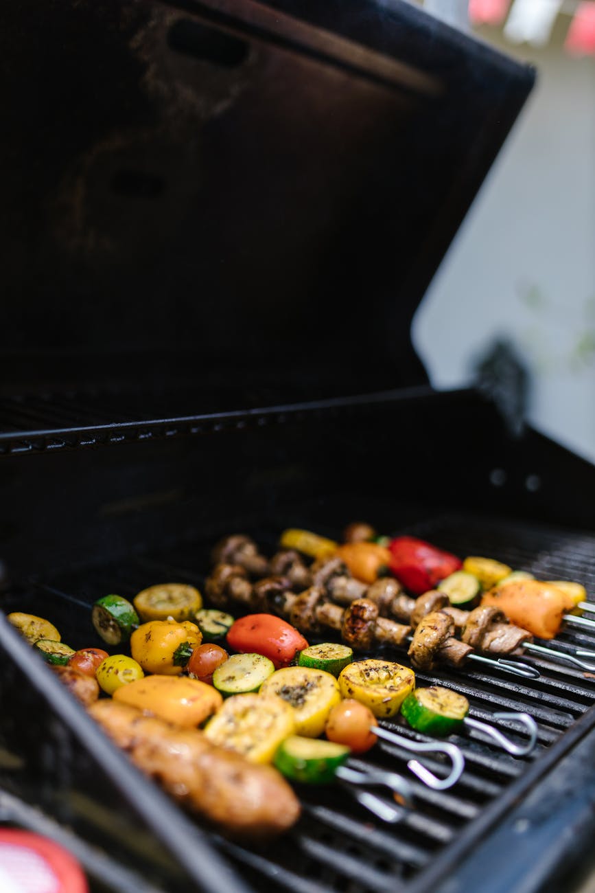 grilling sausage and vegetables on a griller