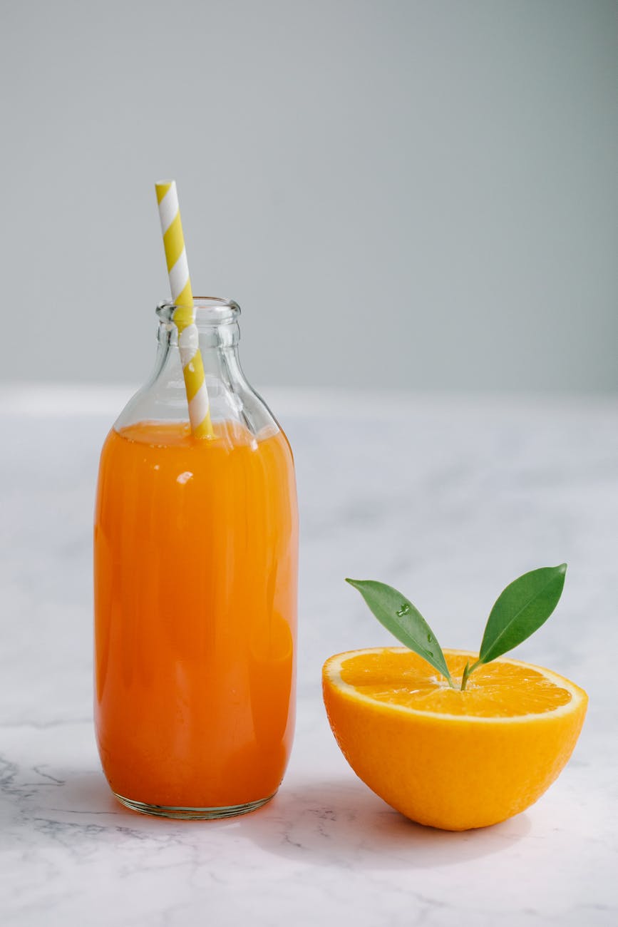 orange juice in clear glass bottle