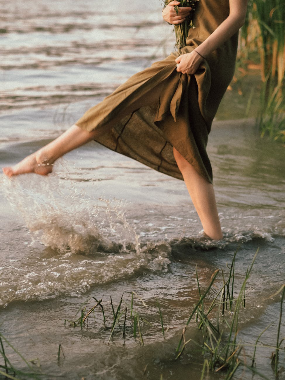 a person in brown dress standing on water