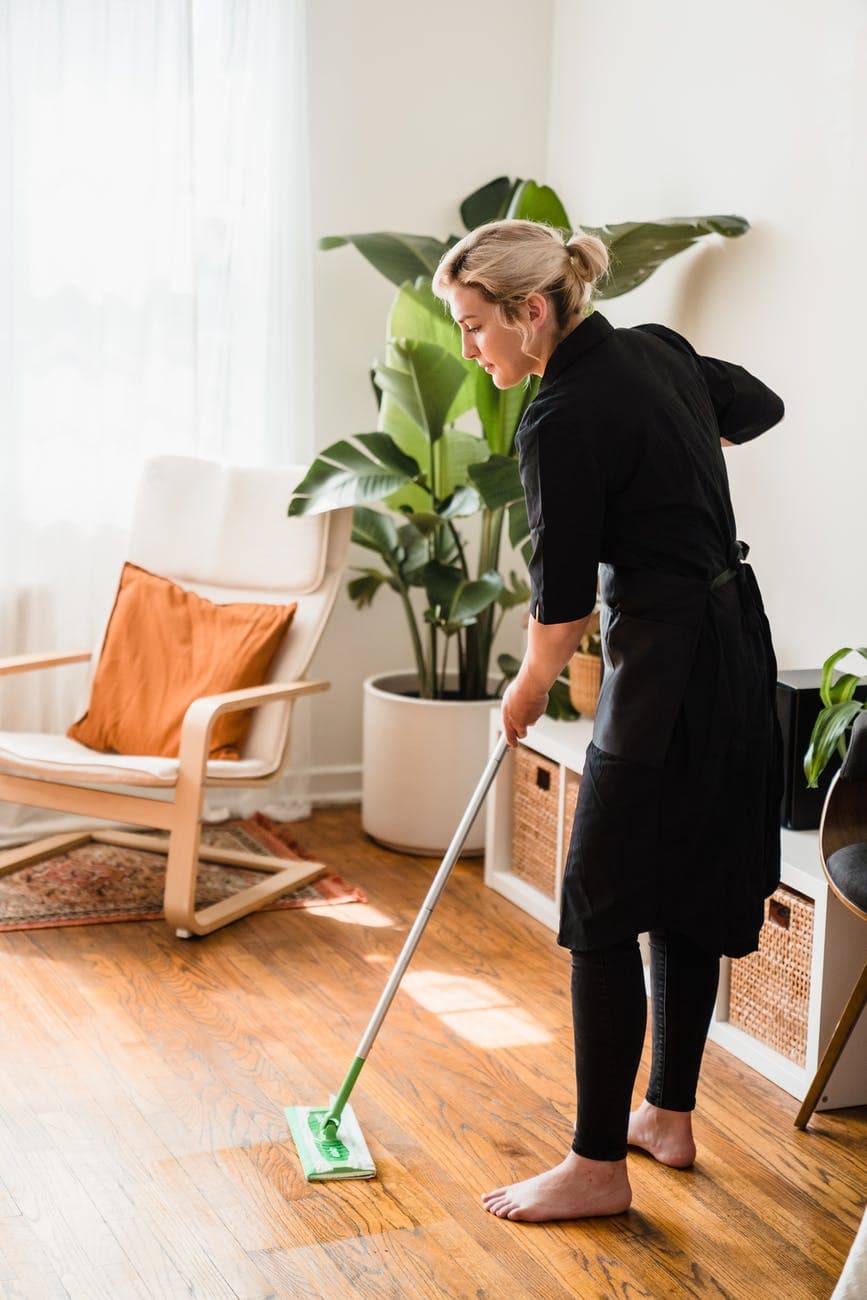 a woman sweeping a floor