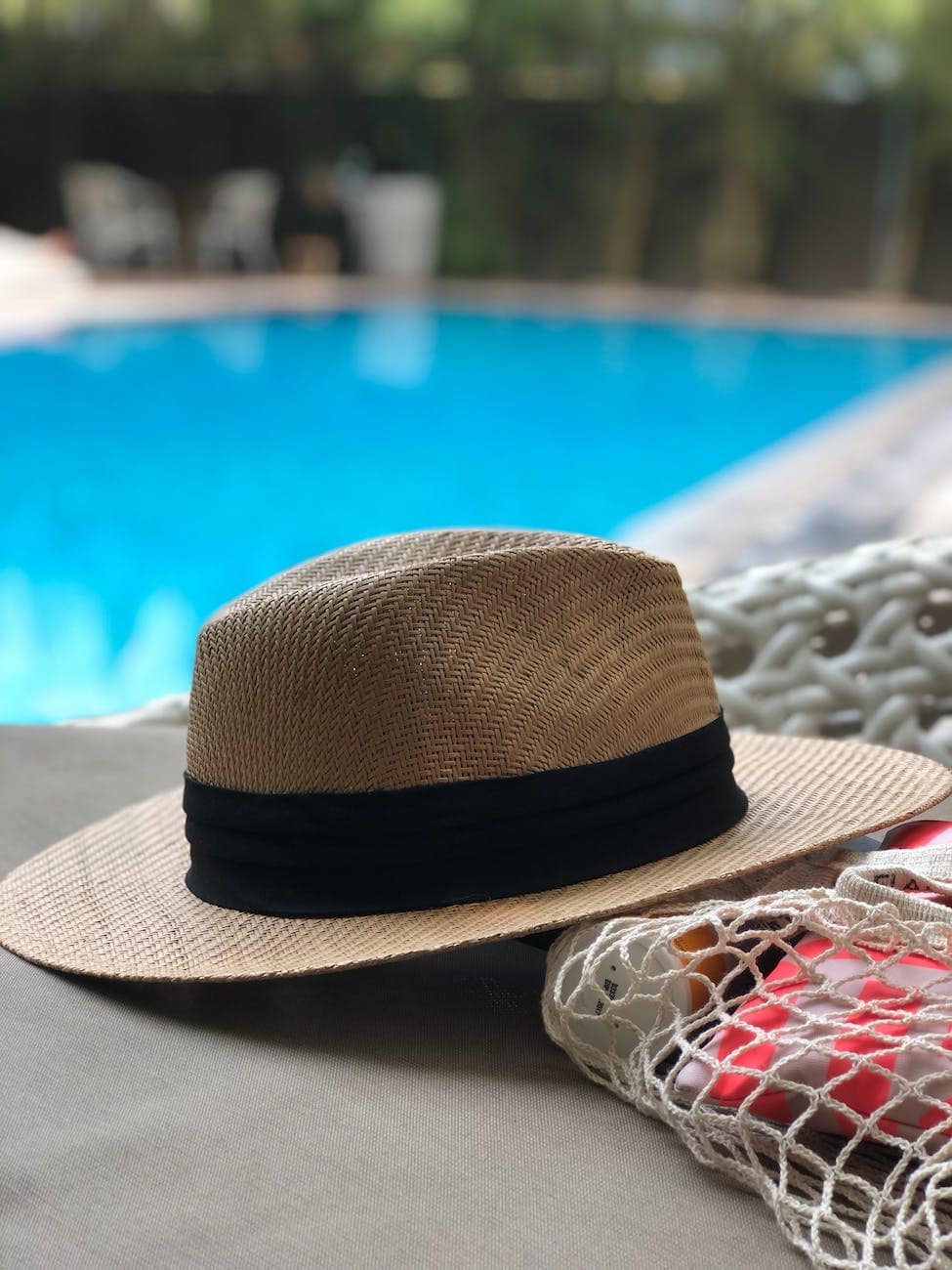 beige and black hat near swimming pool